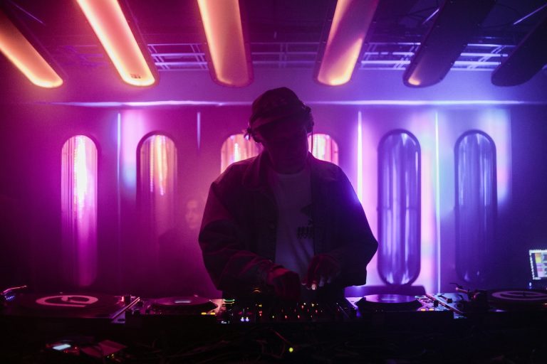 DJ performing under purple lights