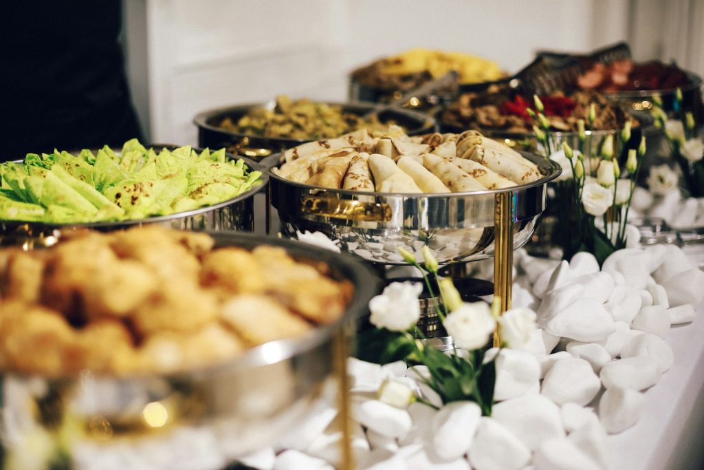Catering buffet with chafing dishes and fresh flowers